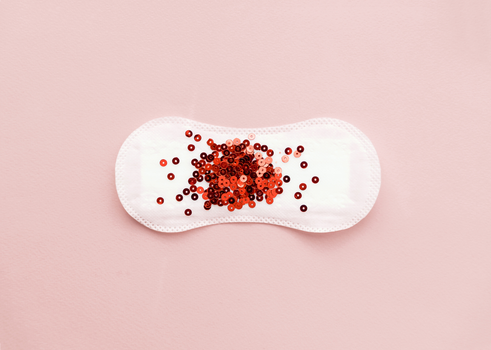 period pad with red glitter - a heavy menstrual cycle concept