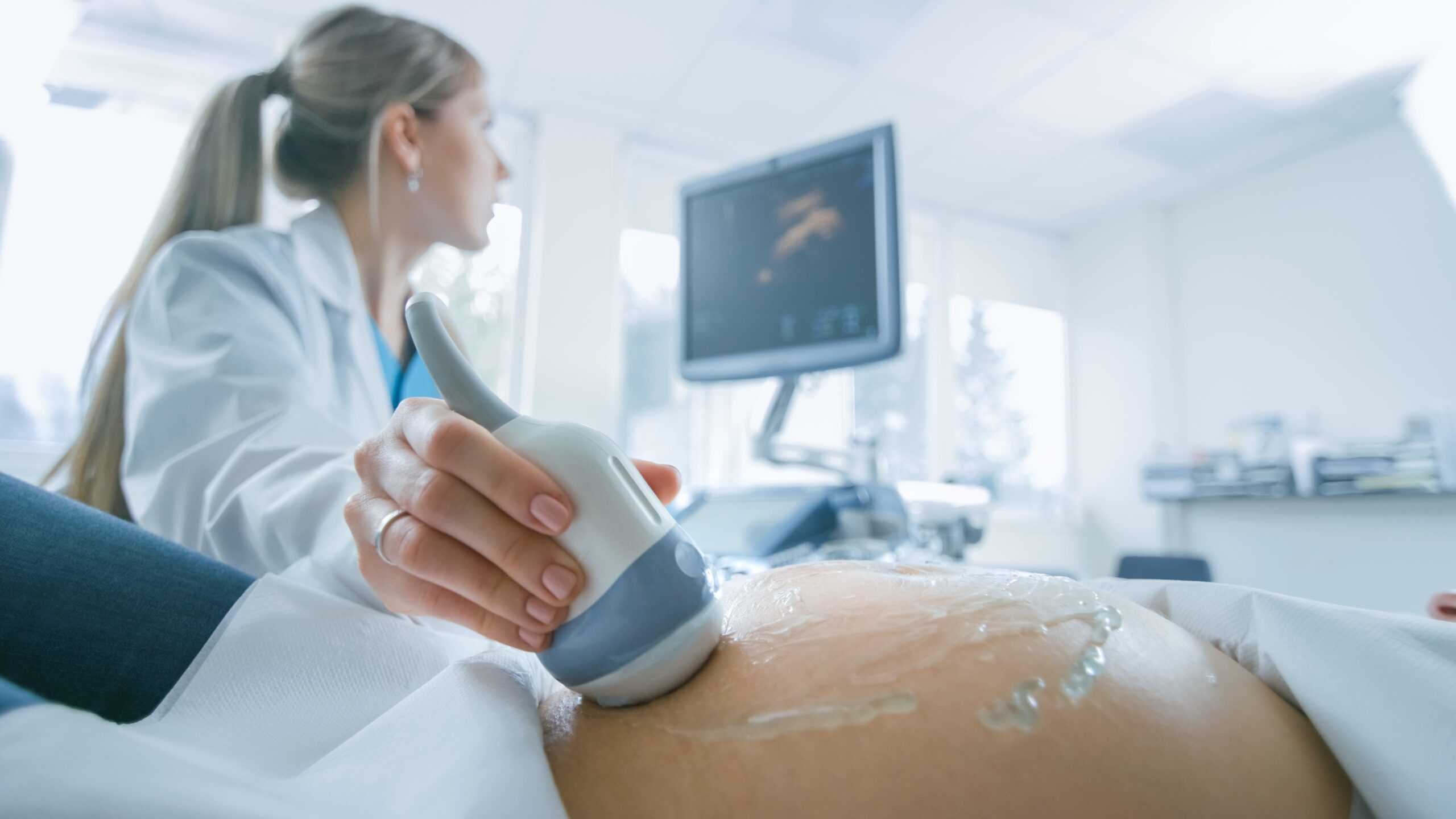 provider performing ultrasound on pregnant patient