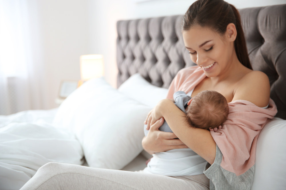 brown haired woman breastfeeding her small baby