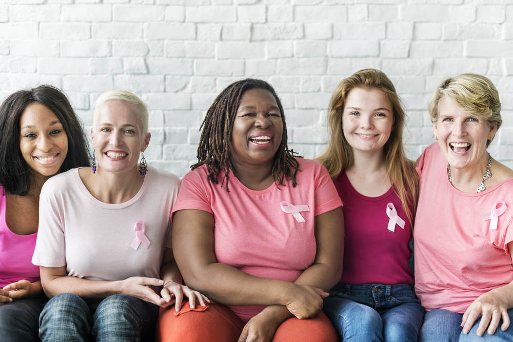 Women sitting together with breast cancer ribbons.